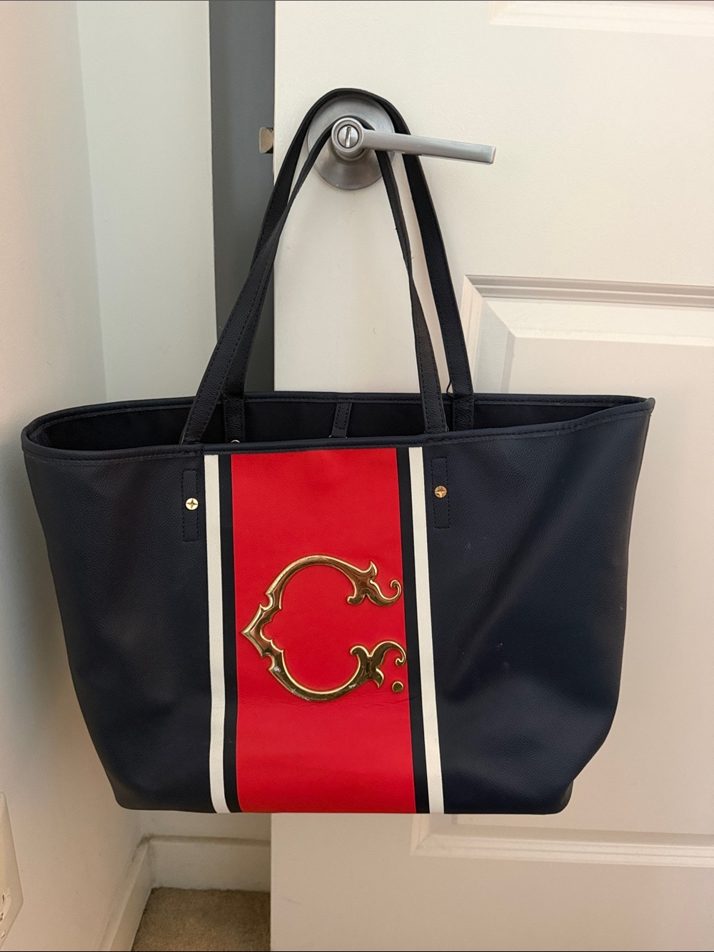 C. Wonder Navy Tote with Red Stripe and Gold Emblem
